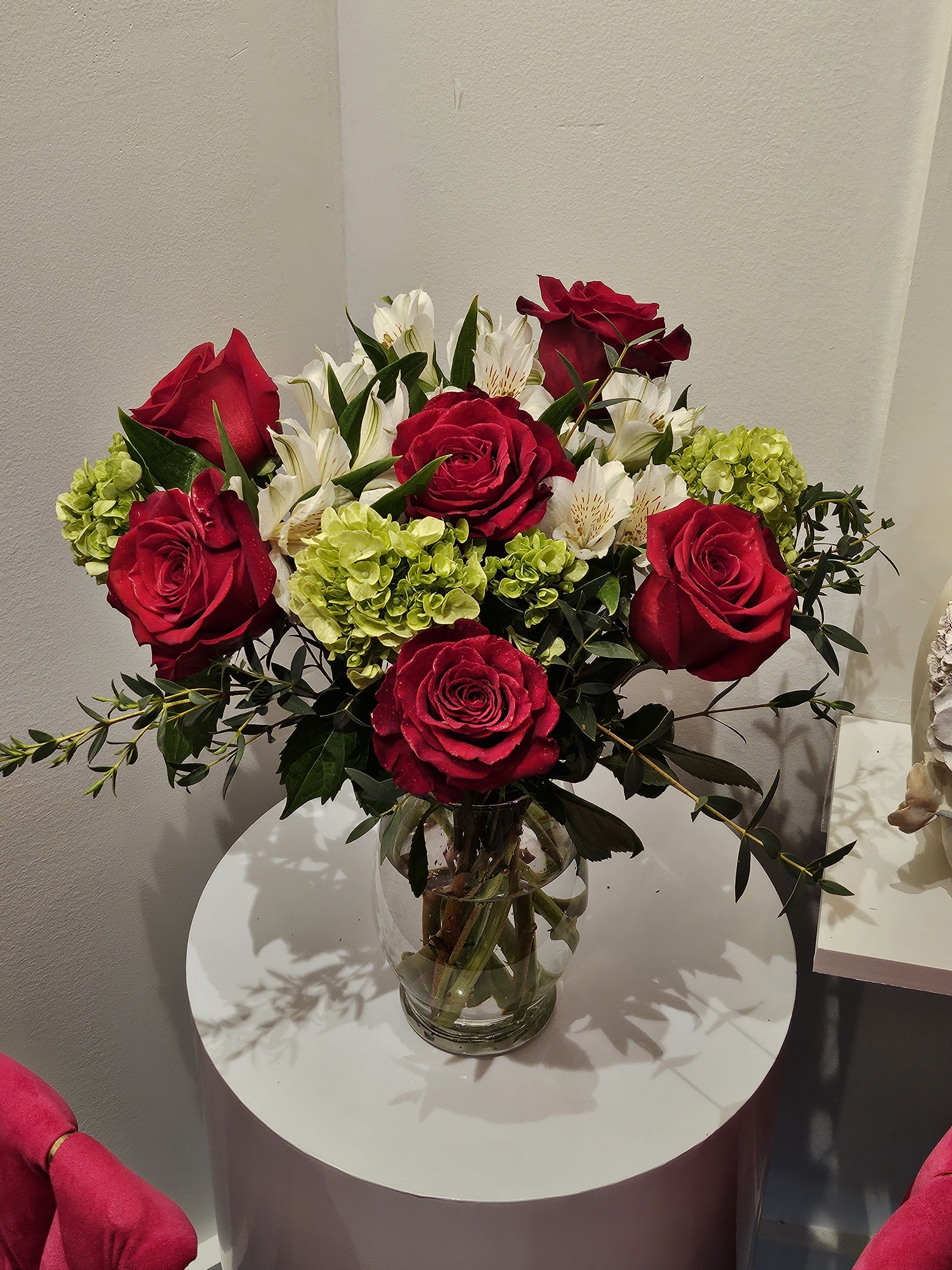 Red roses and white alstroemeria in a clear glass vase