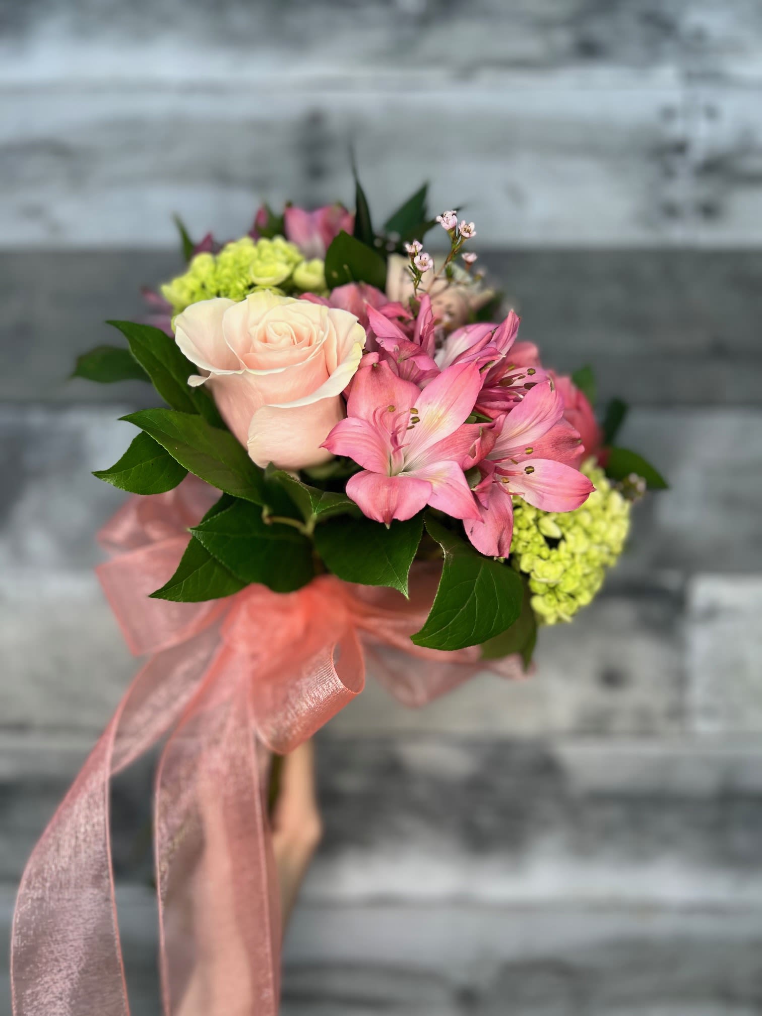 Pink rose bouquet with alstroemeria and green hydrangeas tied with a pink ribbon