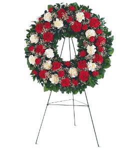 Standing floral wreath of red and white flowers on an easel