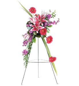 Standing floral spray with pink lilies and magenta daisies on an easel