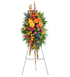 Tall multicolor standing spray of roses, gerbera daisies, and mixed blooms on a metal easel.