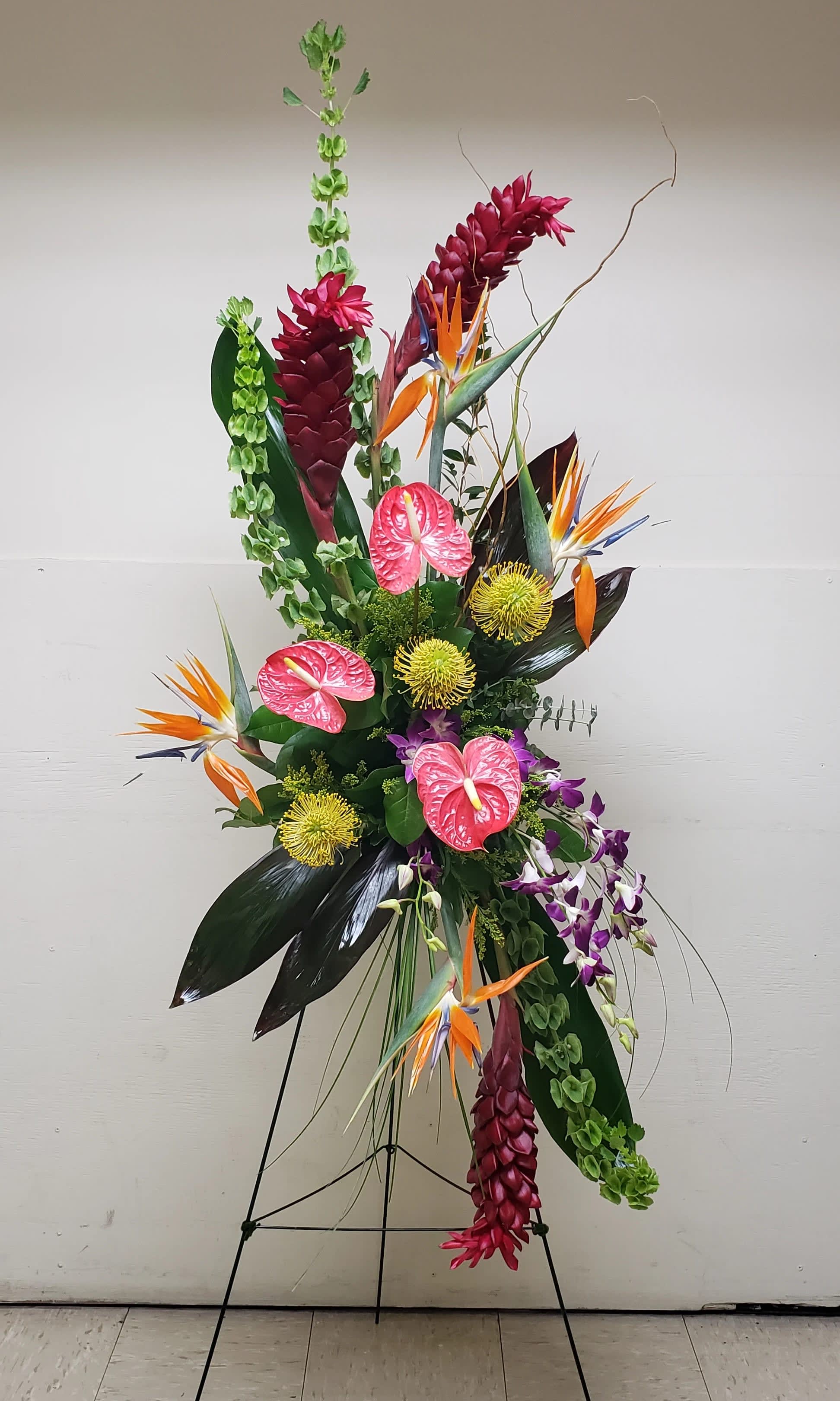 Tall tropical floral arrangement with pink anthuriums and bird of paradise