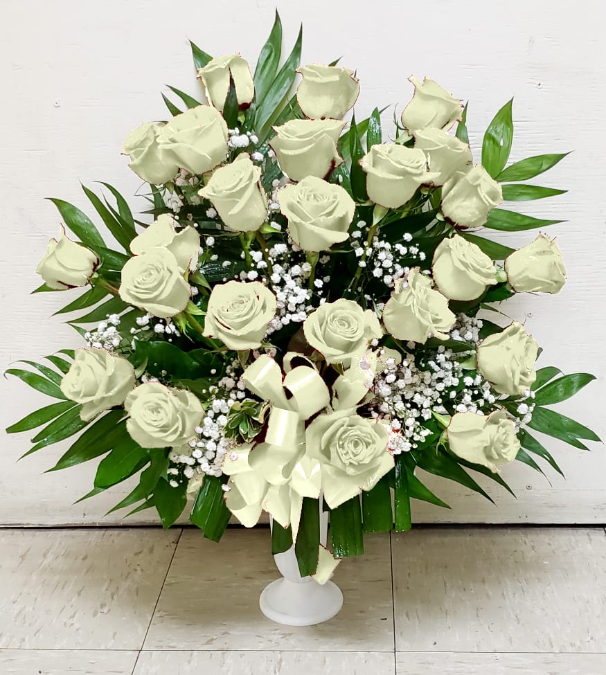 White rose funeral spray in a white pedestal vase