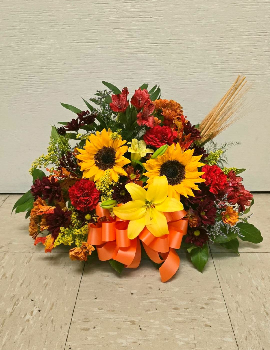Autumn floral arrangement with sunflowers and orange ribbon