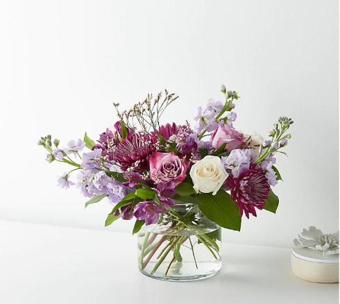 Mixed pink and lavender flowers in a clear glass vase