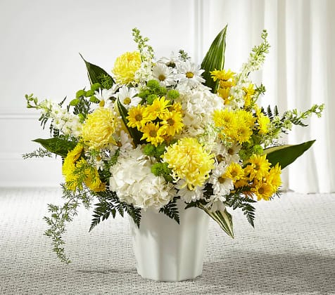 Yellow and white flower arrangement in a white vase