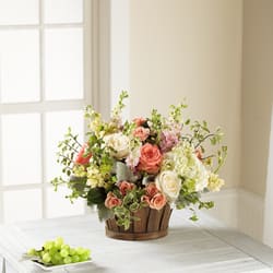 Bountiful Garden Bouquet - Inspired by French country gardens, this captivating flower bouquet has a Victorian styling your recipient will adore. White and salmon roses made the eyes dance while surrounded by pink larkspur, peach spray roses, clouds of white hydrangea, dusty miller stems, and lush greens, arranged to perfection in an oval stained woodchip basket that helps to blend soft sophistication with raw, rustic appeal.  5inch H x 8inch W 