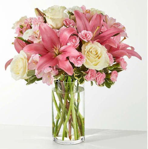 Pink lilies and cream roses in a clear glass vase