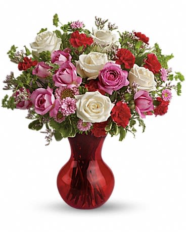Bouquet of pink, white, and red roses in a red glass vase