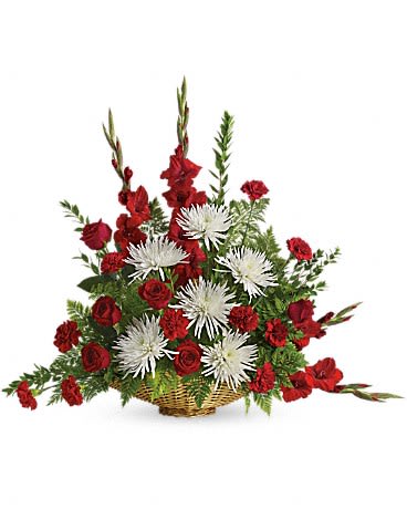 Red and white floral arrangement in a wicker basket