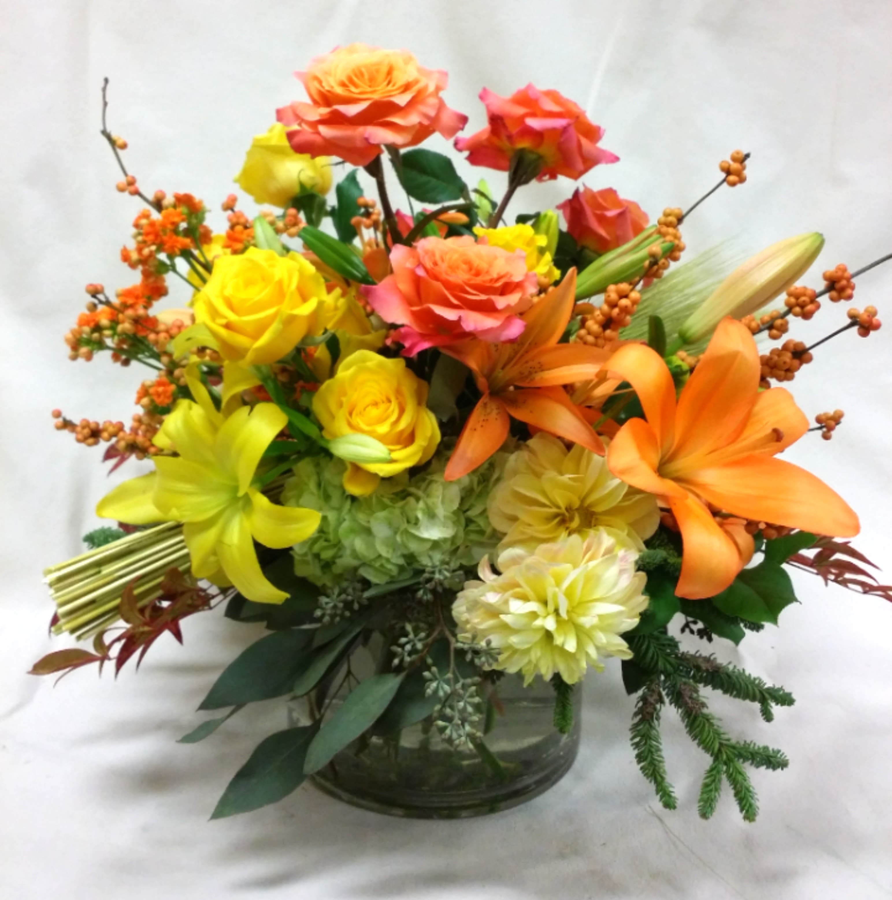 Colorful bouquet of roses and lilies in a glass vase