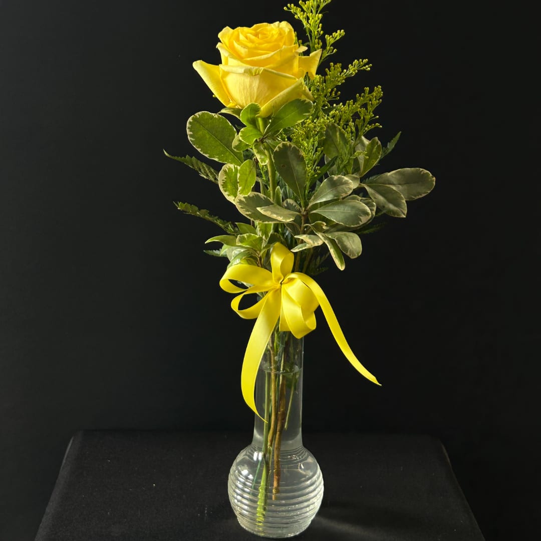 Yellow rose in a clear glass vase with a yellow ribbon