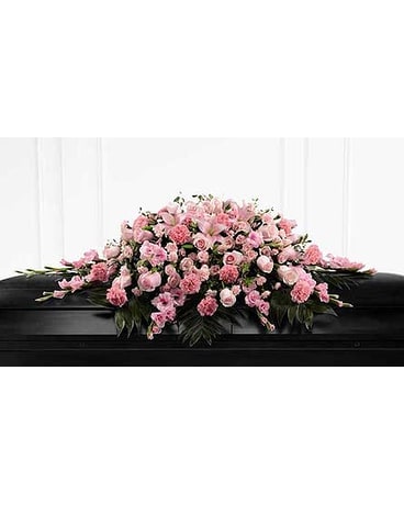 Pink floral casket spray on a black casket