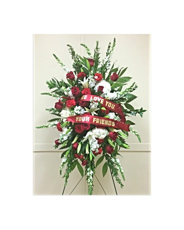 Standing floral spray with red roses and white flowers on an easel