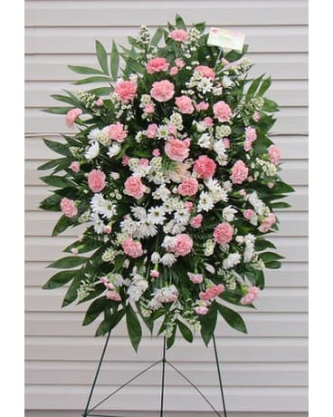 Standing floral spray with pink and white carnations on a metal easel