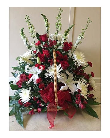 Red and white floral basket arrangement with a red ribbon