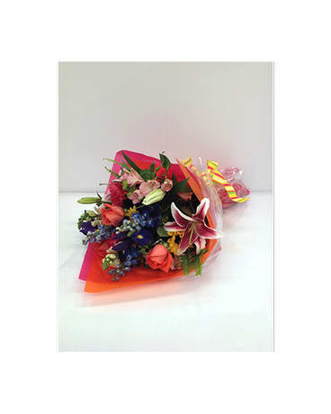 Colorful bouquet with lilies and roses wrapped in bright paper
