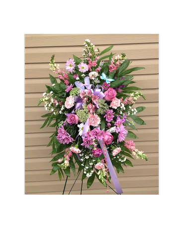 Standing floral spray with pink and purple flowers on an easel