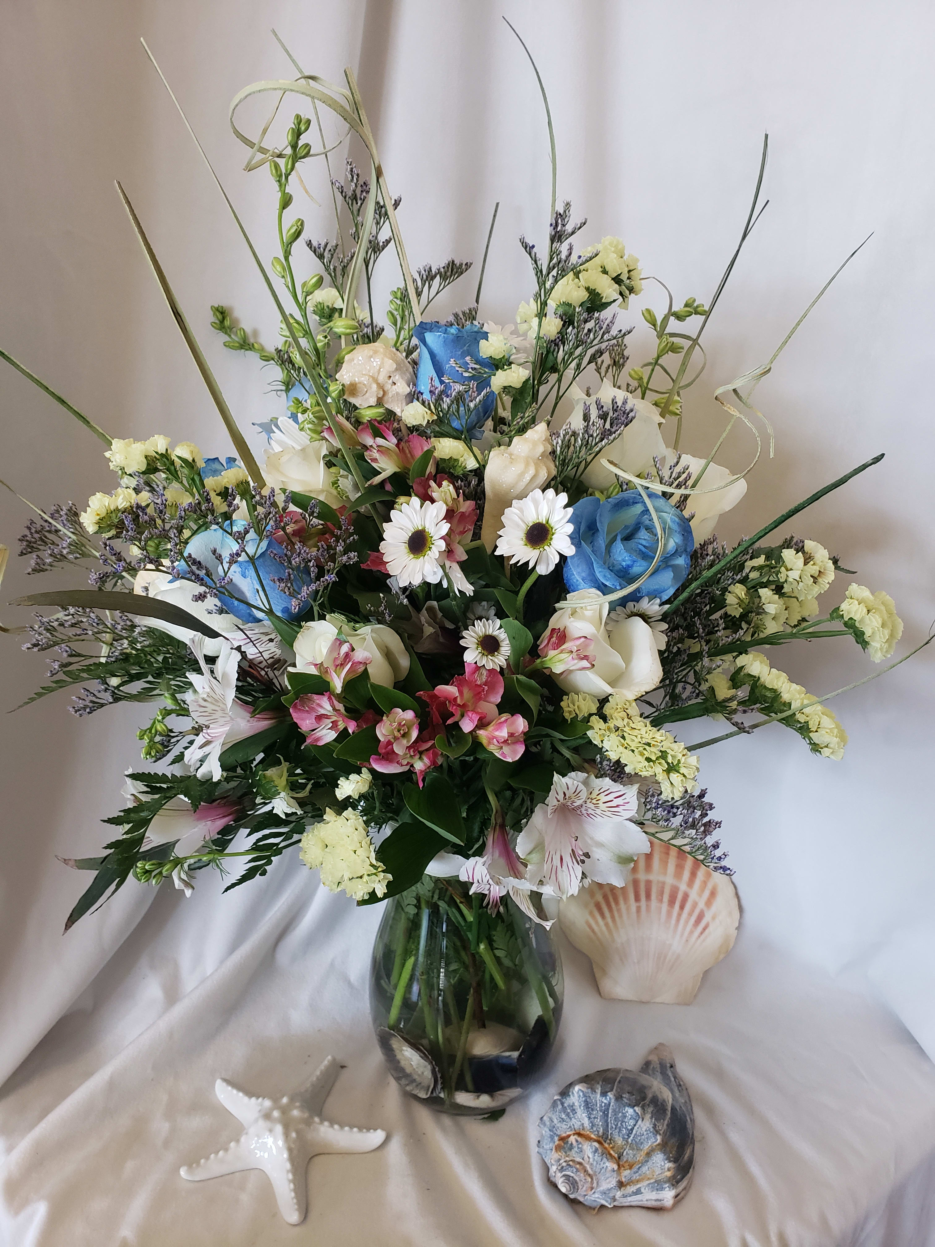Mixed bouquet in a glass vase with blue, white, and pink flowers