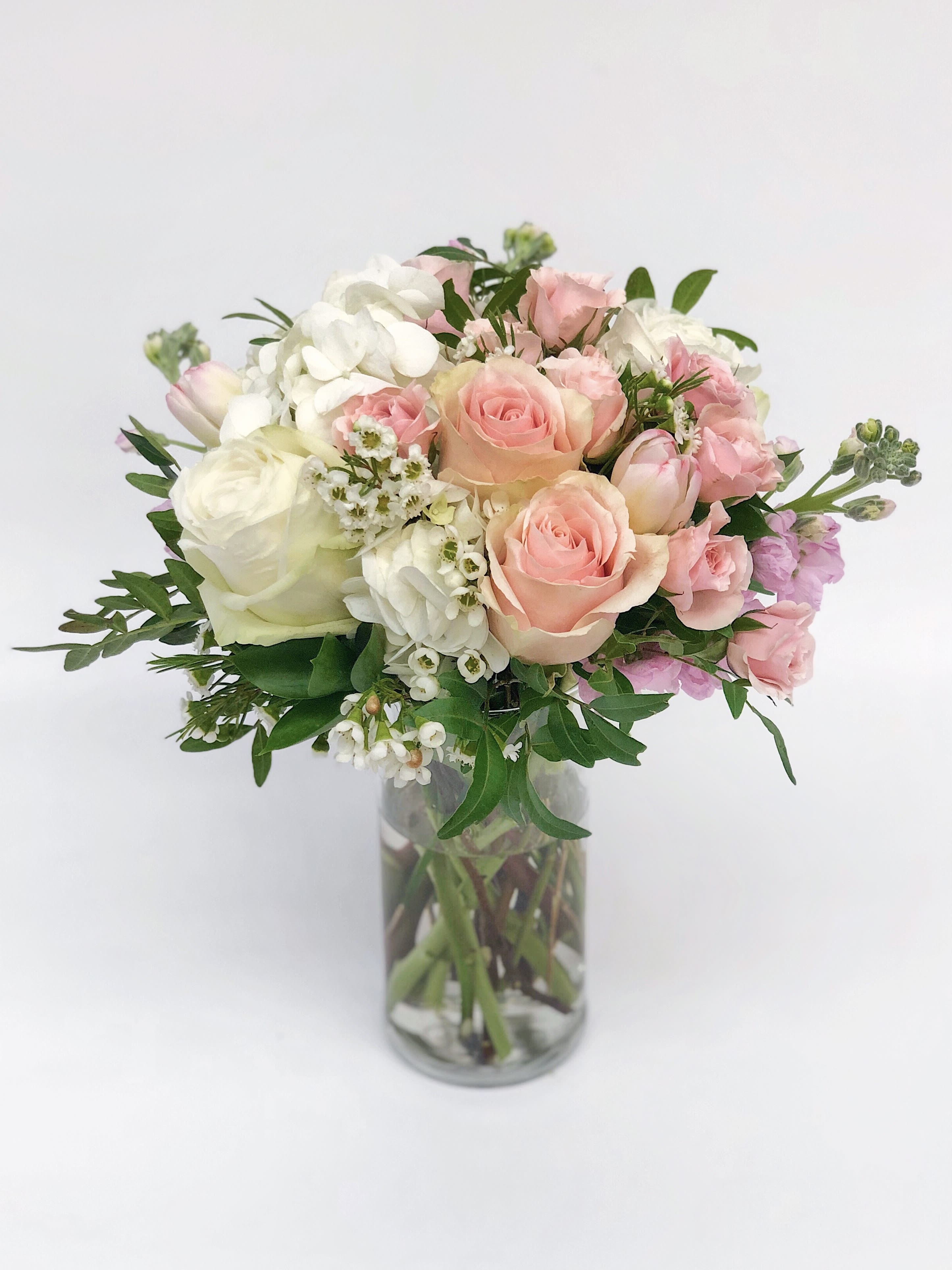 Pink and white rose bouquet in a clear glass vase