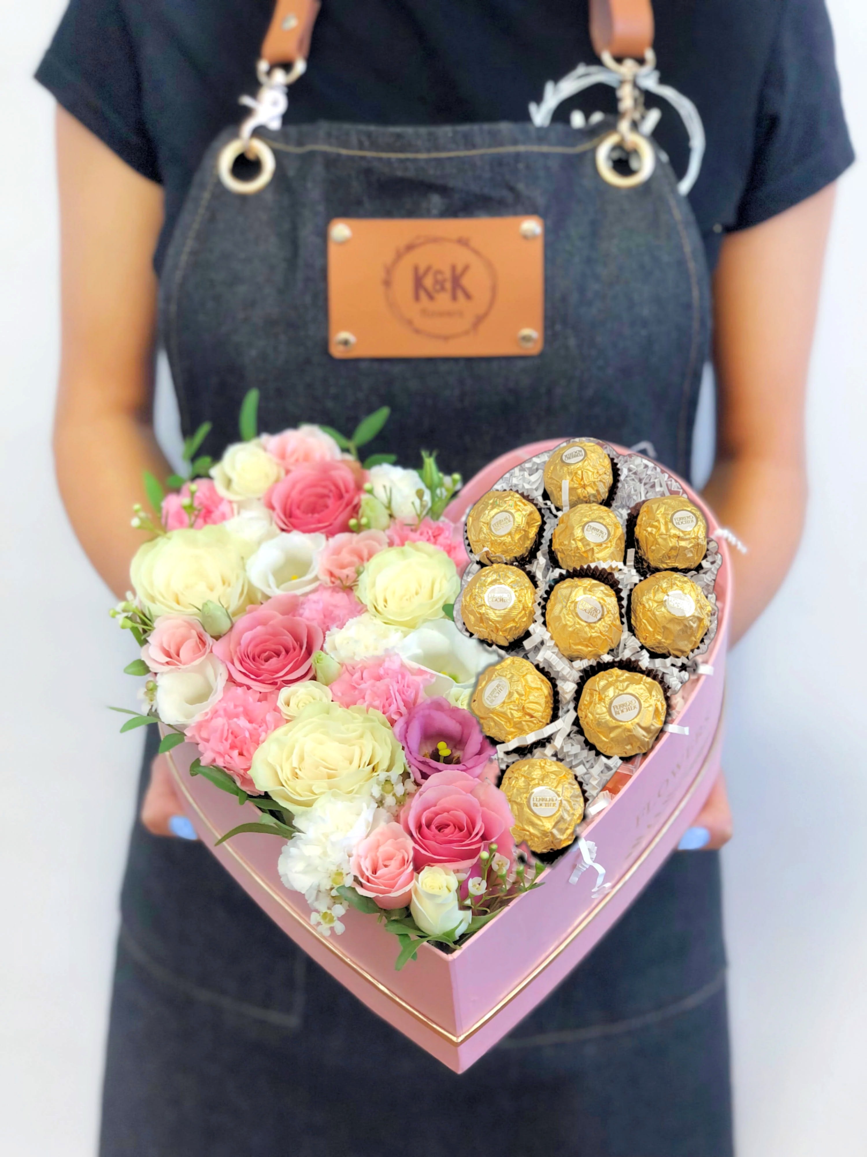 Flowers &amp; Ferrero Heart Box Pink And White - Standard: Heart-shaped box (10"x10") with mixed flowers and 12 Ferrero Rocher	 Deluxe: Heart-shaped box (13"x13") with mixed flowers and 18 Ferrero Rocher	  Mixed flowers, from romantic and gentle to an edgy and interesting look. If You want a bouquet with a twist, choose our flower boxes. We have wood boxes for rustic-looking arrangements or hat boxes for a more elegant look. It’s a beautiful and convenient way. Flowers in boxes don’t need vases. That makes it perfect for transportation and keeping flowers hydrated and secure