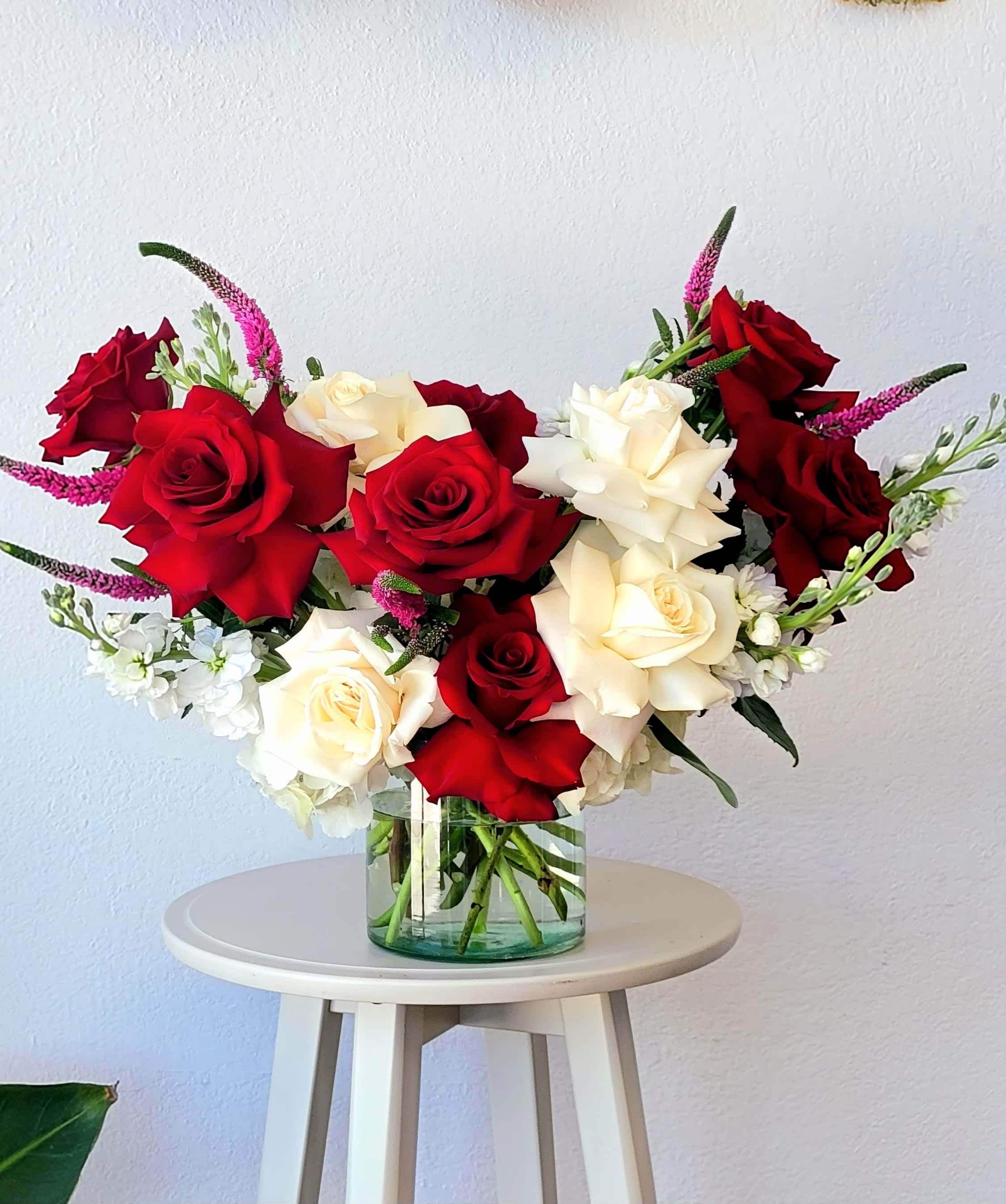 Red and white roses in a clear glass vase