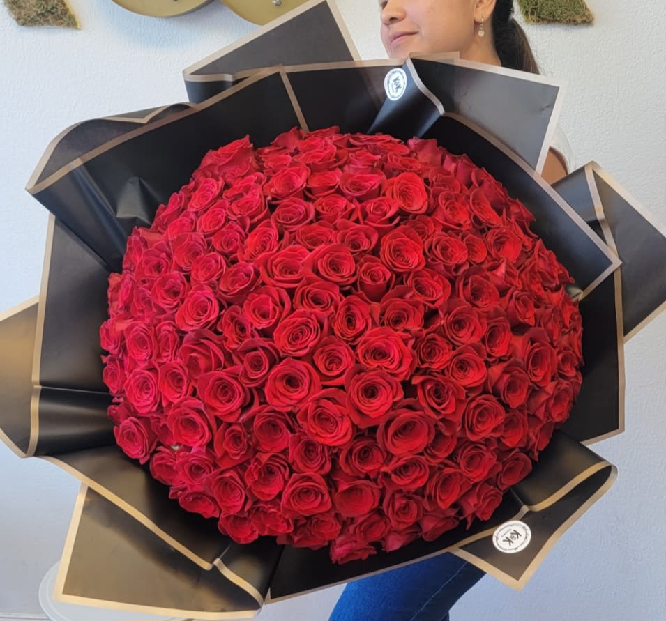 Large bouquet of red roses wrapped in black paper