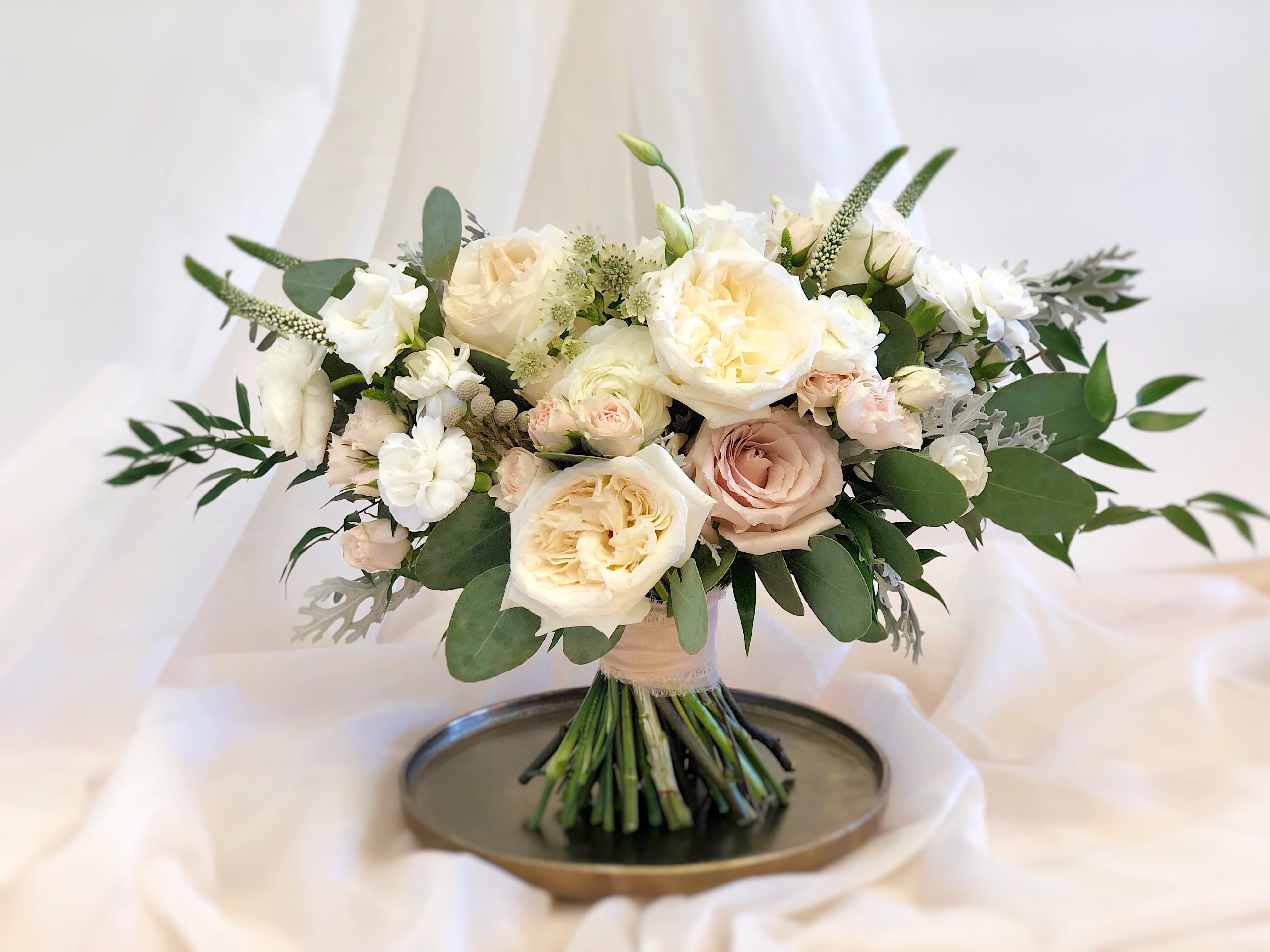 Cream and blush rose bouquet with greenery on a tray