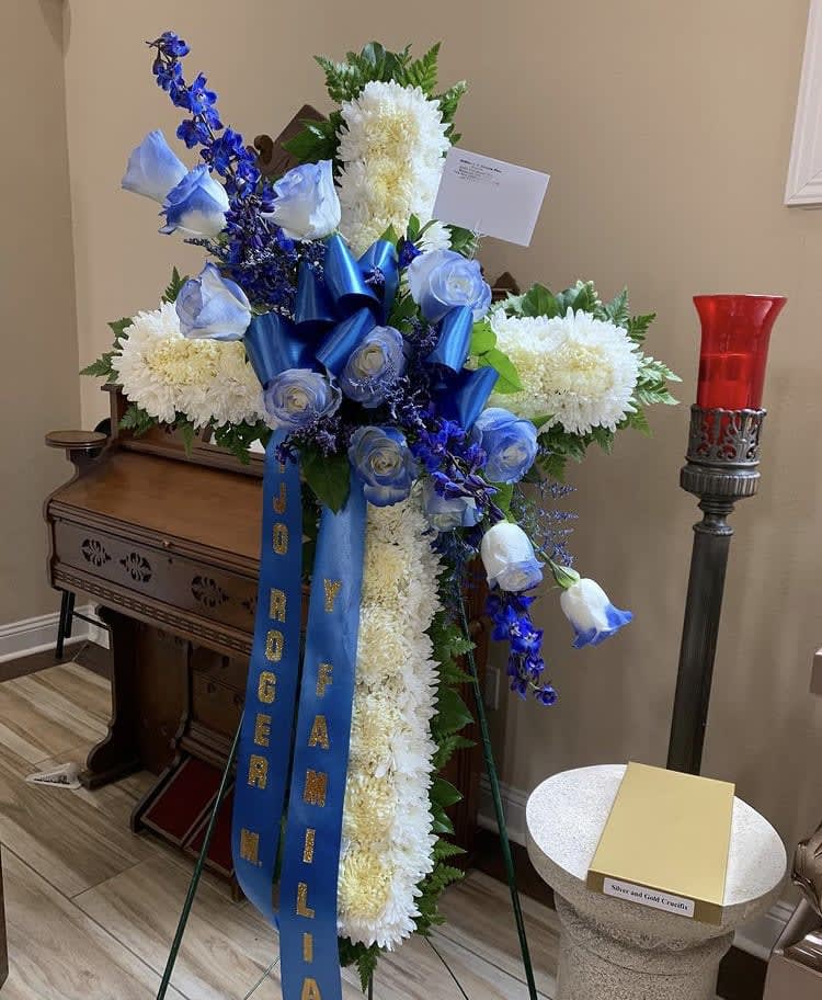 Standing funeral spray with white chrysanthemums, blue roses, and blue ribbons