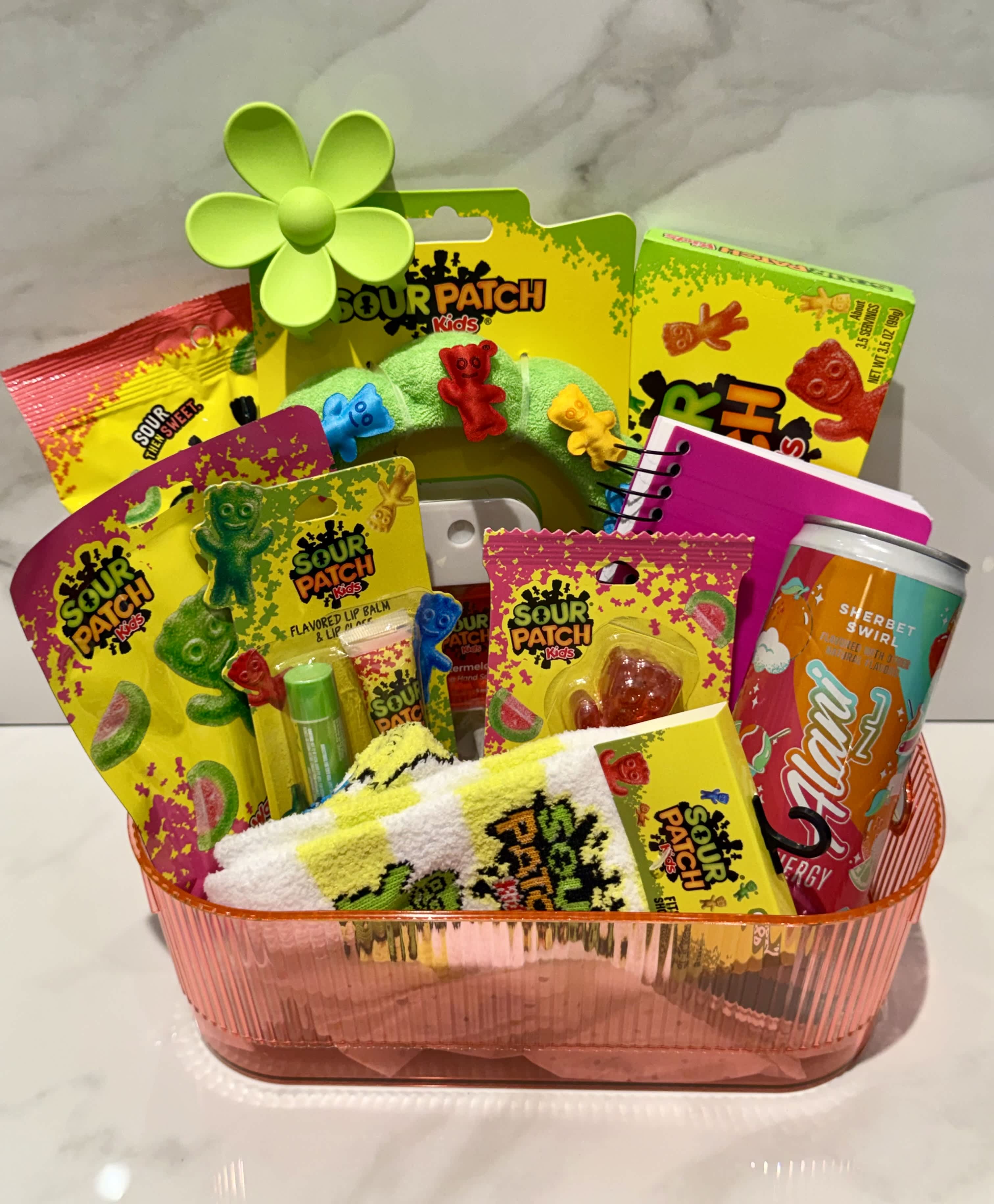 Gift basket with Sour Patch Kids candy, a can, and small accessories