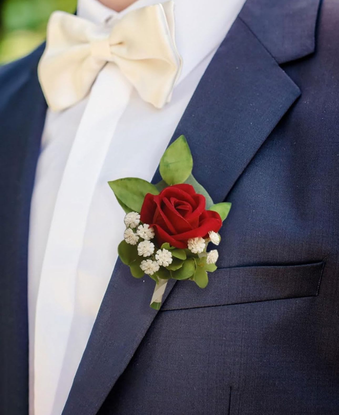 Red rose boutonniere on a navy suit with a white bow tie