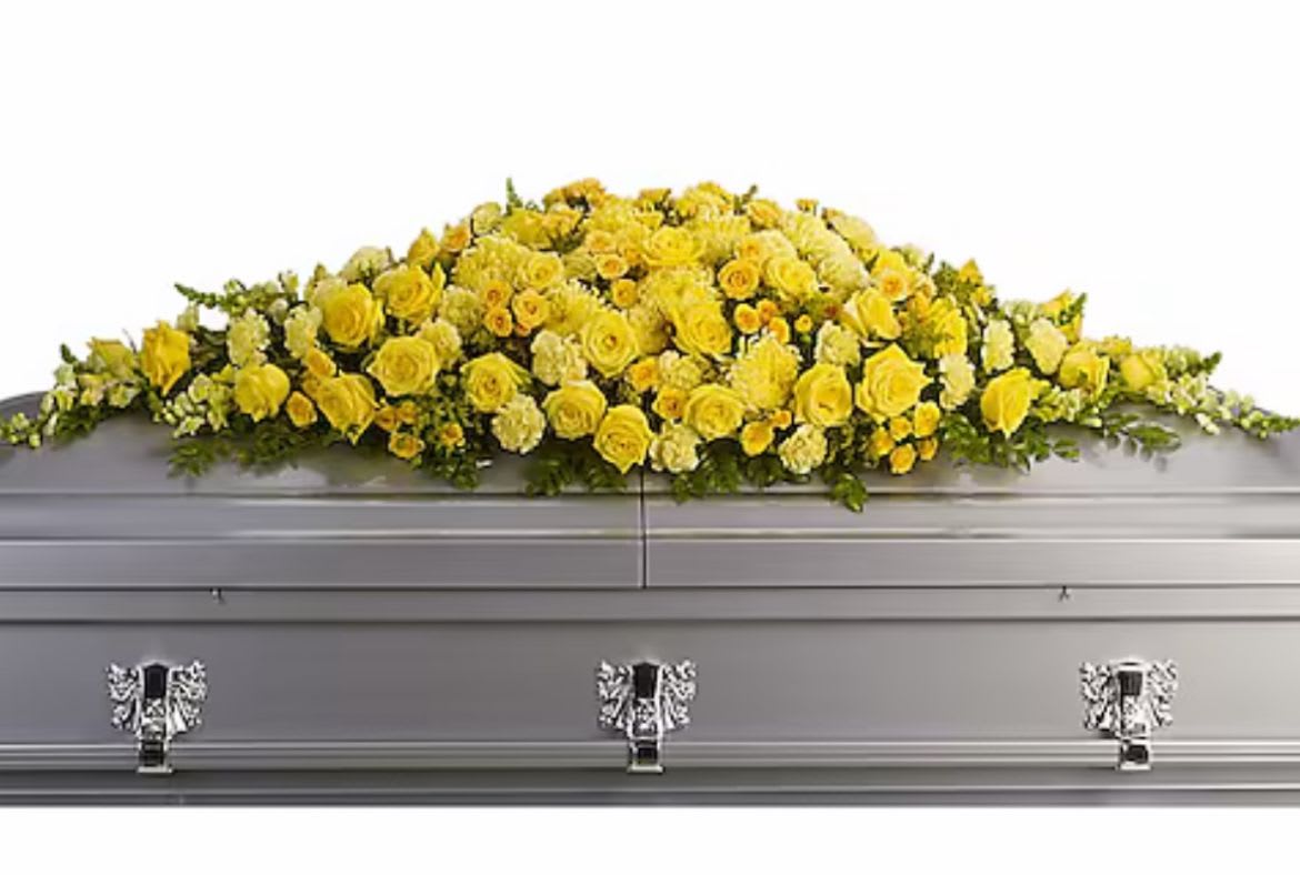 Yellow Embrace  - Yellow Embrace is crowned with a lush arrangement of yellow roses, carnations, chrysanthemums, snapdragons, and spray roses. Overflowing with warmth and grace, this setting honors a life filled with light, compassion, and quiet strength. A final resting place bathed in golden hues — a tender goodbye wrapped in sunshine. DISCLAIMER: Flowers may be substituted if needed to. 