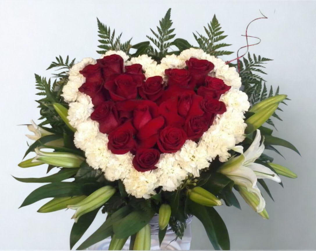 I Love You  by D'Lily's Flowers  - This favorite is a heart shaped filled with reds and some whites and greenery to complete this lovely heart.
