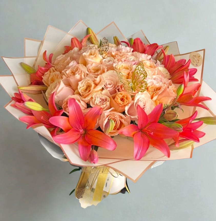 Peach Roses &amp; Lilys Bouquet by D'Lily's Flowers  - An all peach roses and red lily combination to bring out the perfect smile from that special someone. Disclaimer: This is a wrapped bouquet. No Vase is Included. 