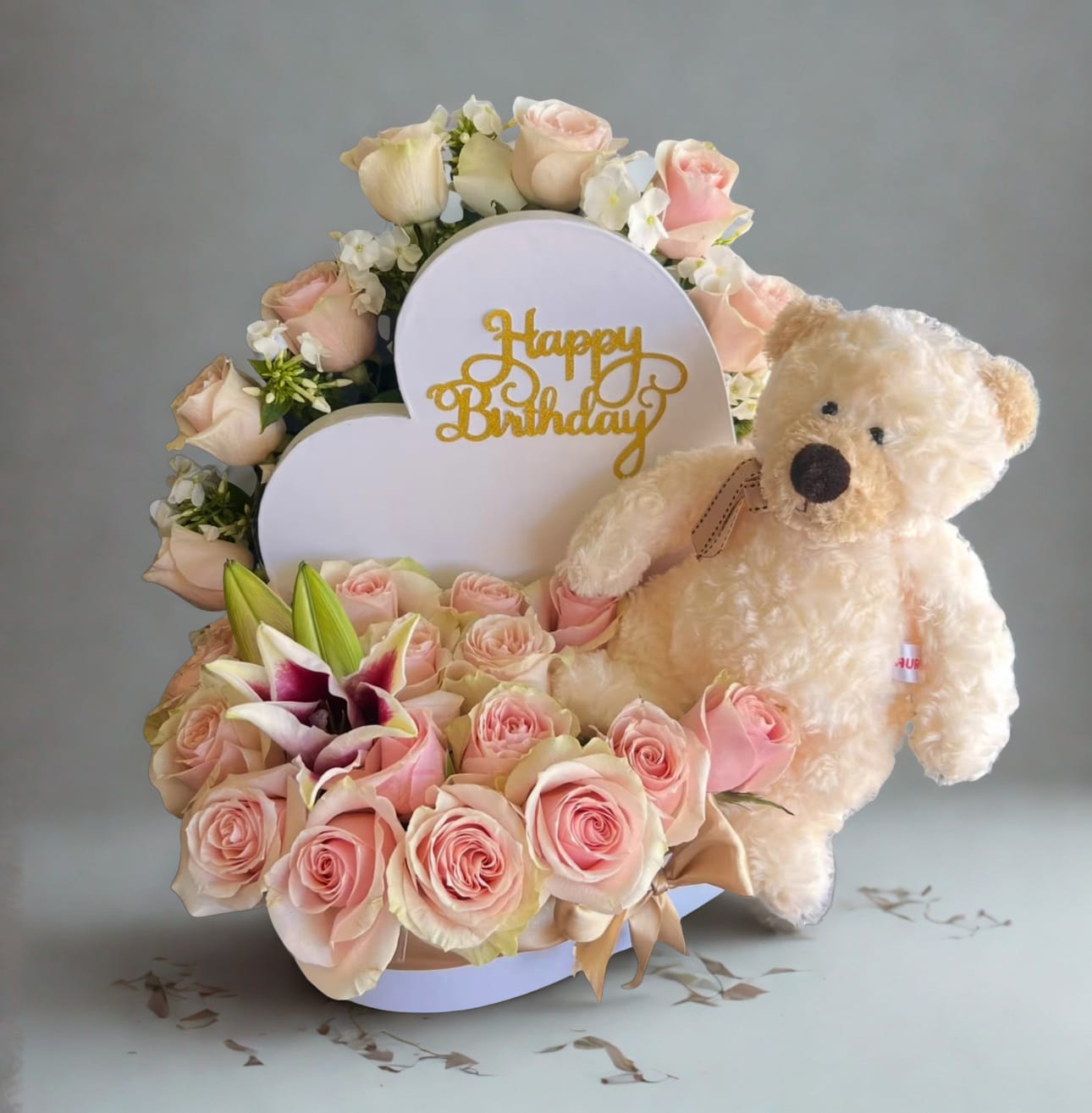 Teddy &amp; Blooms Birthday Delight by D'Lily's Flowers  - Make their birthday extra special with this sweet arrangement of blush pink roses, fresh lilies, and a cuddly teddy bear. Finished with a golden "Happy Birthday" sign, it’s the perfect mix of beauty and charm in one heartfelt gift. DISCLAIMER: Teddy bear may be substituted if needed too.  
