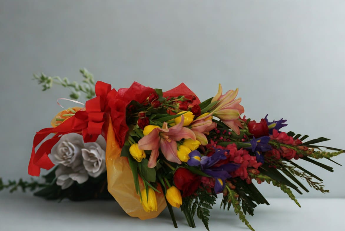 Happy Bouquet  by D'Lily's Flowers  - This colorful bouquet has a one sided display with different colors for a bright look and it will make it perfect for any occasion. Disclaimer: This is a wrapped bouquet. No Vase is Included. 