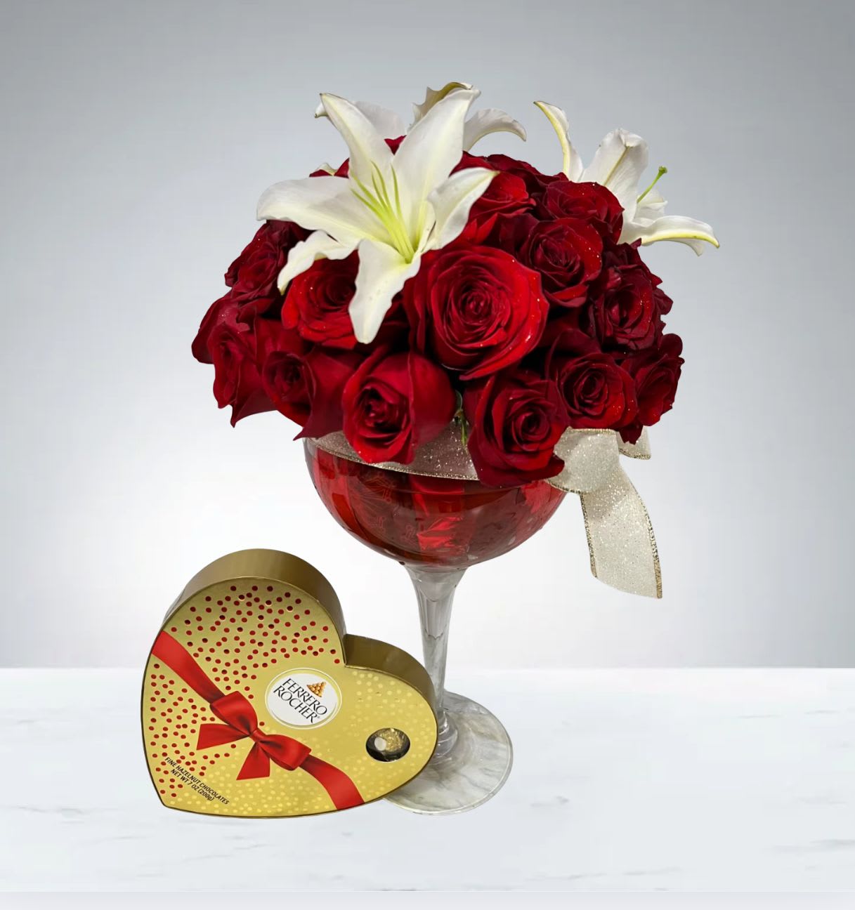 Full of love  by D'Lily's Flowers  - This set comes with a beautiful rose arrangement mixed with lilies in a beautiful tall cup vase with some delicious chocolates. 