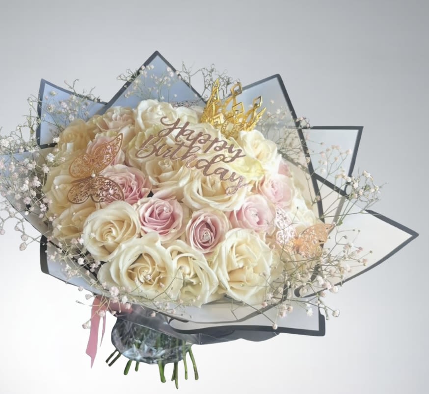 Bouquet of cream and pink roses with a "Happy Birthday" topper