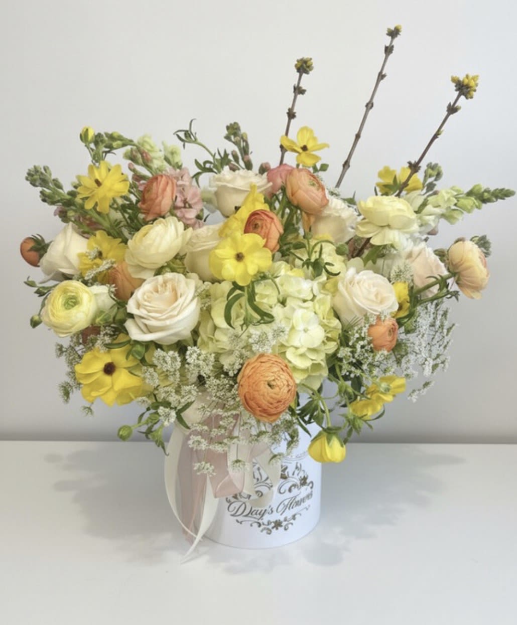 Mixed pastel bouquet in a white hatbox with a ribbon