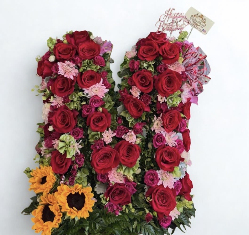 Letter Box Flowers  - Looking for a unique and beautiful gift? These floral letter box arrangements can be customized with any letter of your choice! The example shown features red roses, hotpink spray roses, filler daises, bells and sunflowers in the letter "M", but any letter can be created to fit your special occasion.  Perfect for birthdays, anniversaries, graduations, baby showers, and more.  Please preorder at least 3–5 days in advance to allow time for customization and flower selection.