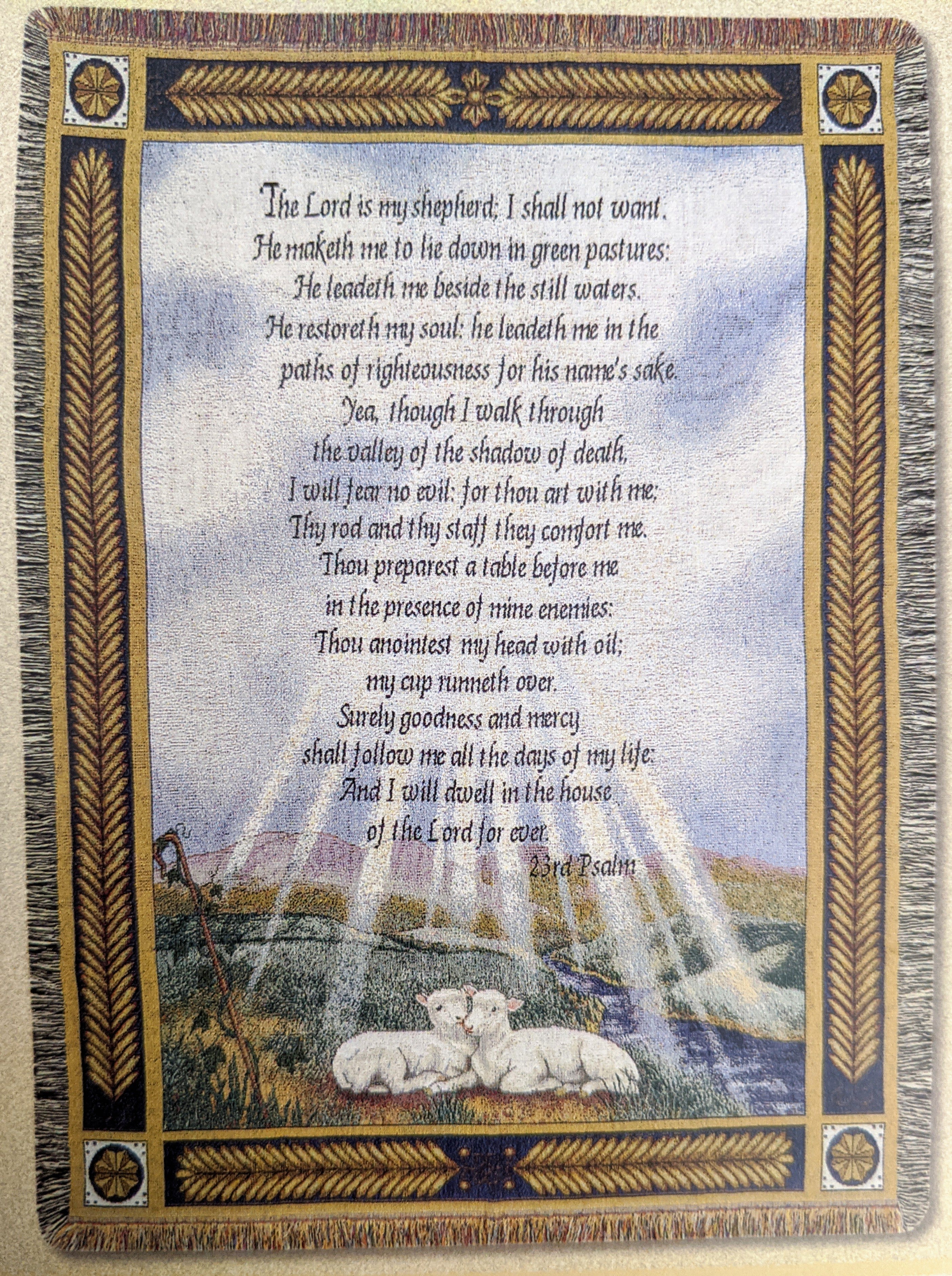 Decorative wall hanging with Psalm 23 text and two lambs in a pastoral scene