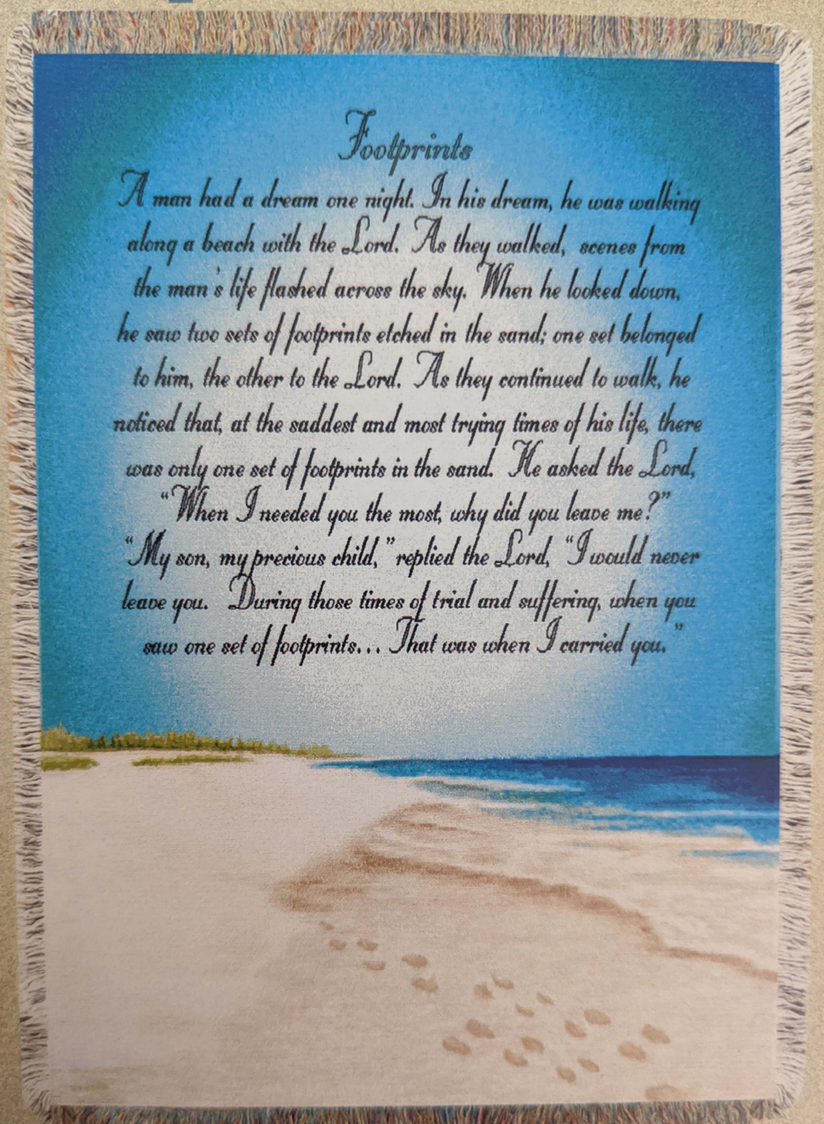 Fringed wall hanging with a beach scene and printed poem text