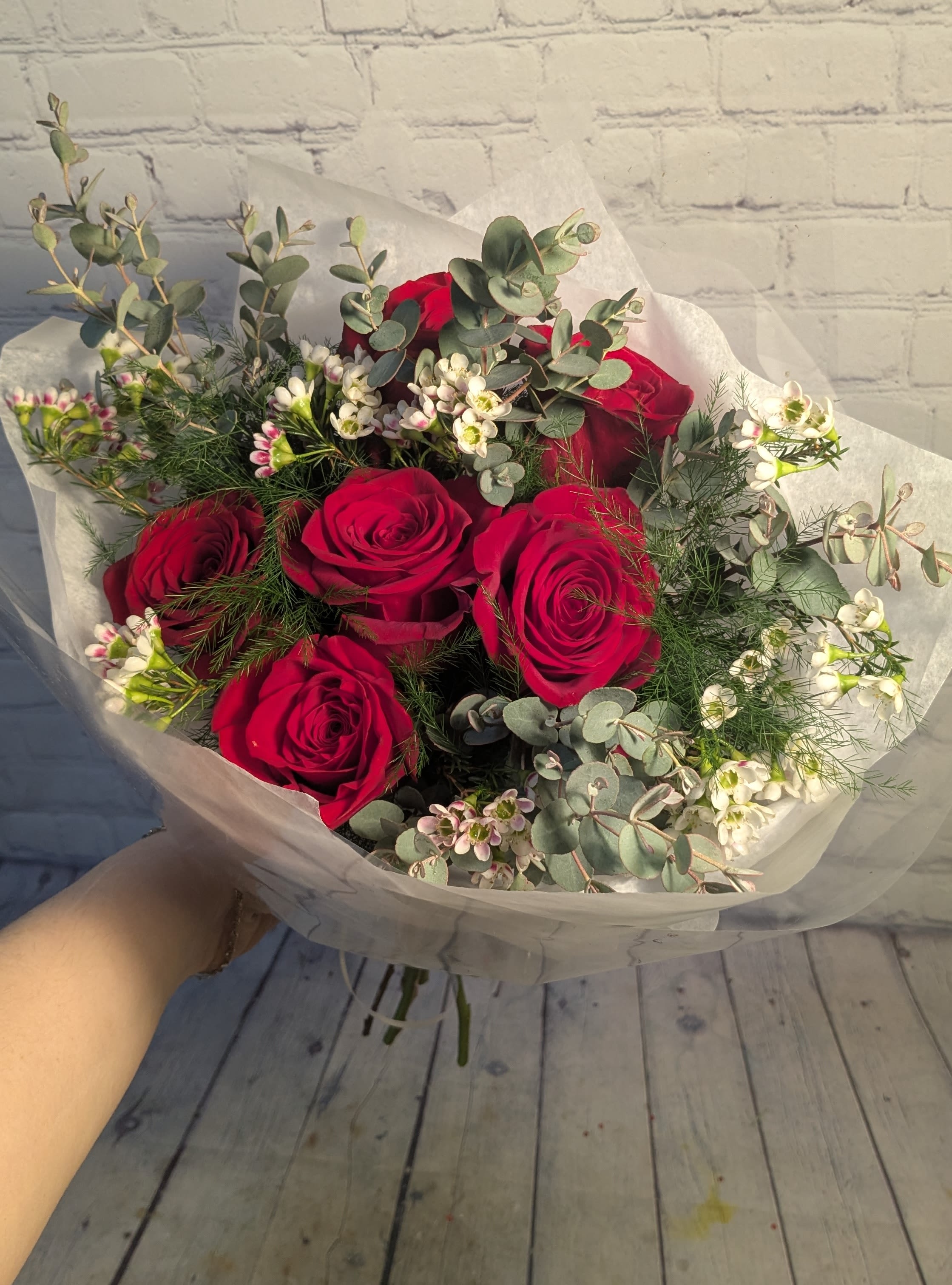 Bouquet of red roses with white filler flowers and eucalyptus