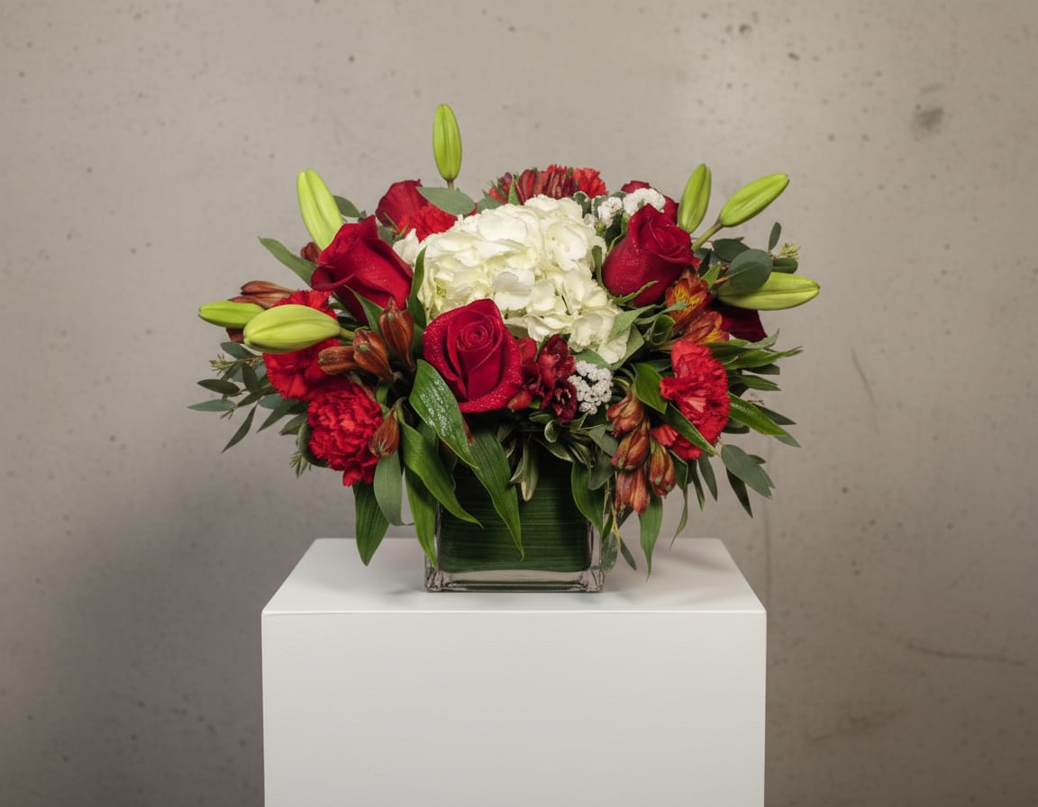 Red roses and white hydrangea in a square glass vase