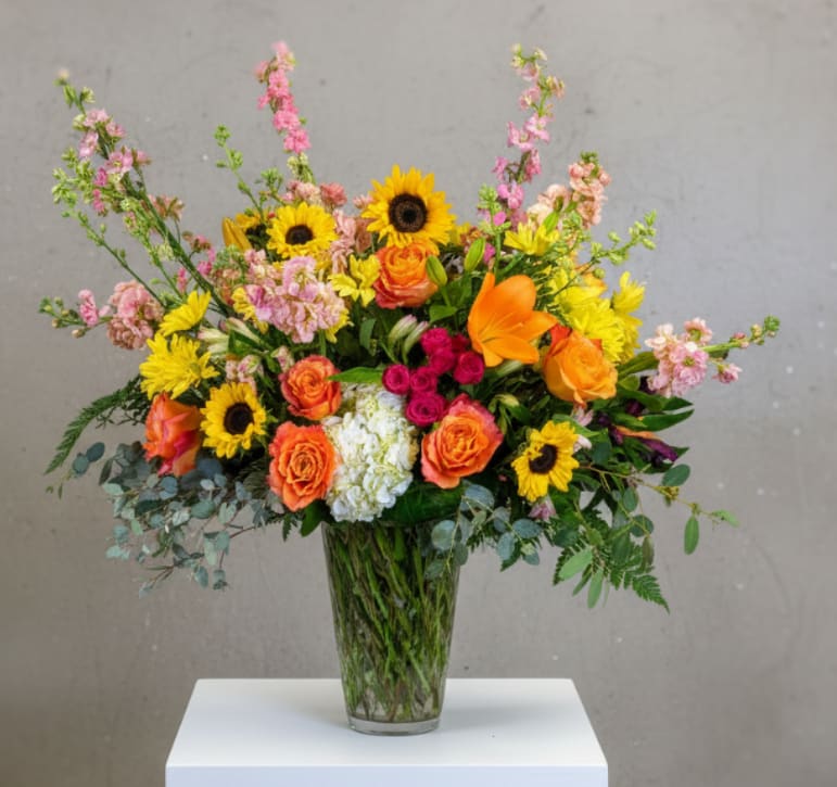 Sunset - Sunset is a vibrant, large-scale bouquet inspired by the warm glow of a summer evening. Featuring sunset hues and sweet seasonal blooms, this arrangement is thoughtfully hand-arranged in a generous vase to create a bold, radiant display. Perfect for celebrations, thank-yous, or making a lasting impression, Sunset brings warmth and color to any space.
