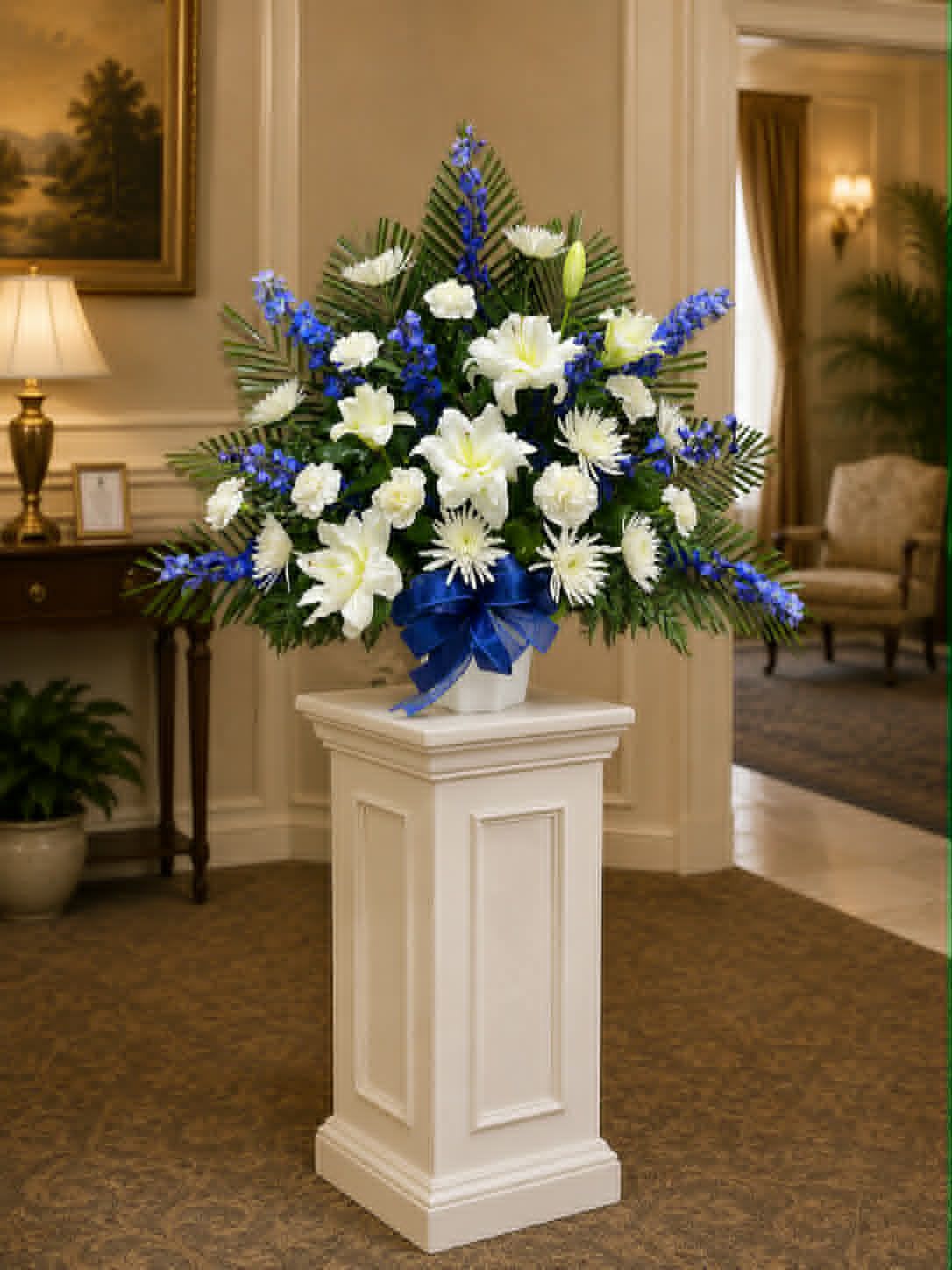 TB9 Traditional Basket - Sympathy mache - includes white spider mums, white daisies, dark blue delphinium, baby's breath, greens, and bow.  Banners not included $15 + per banner   Substitutions may apply pending flower availibilty