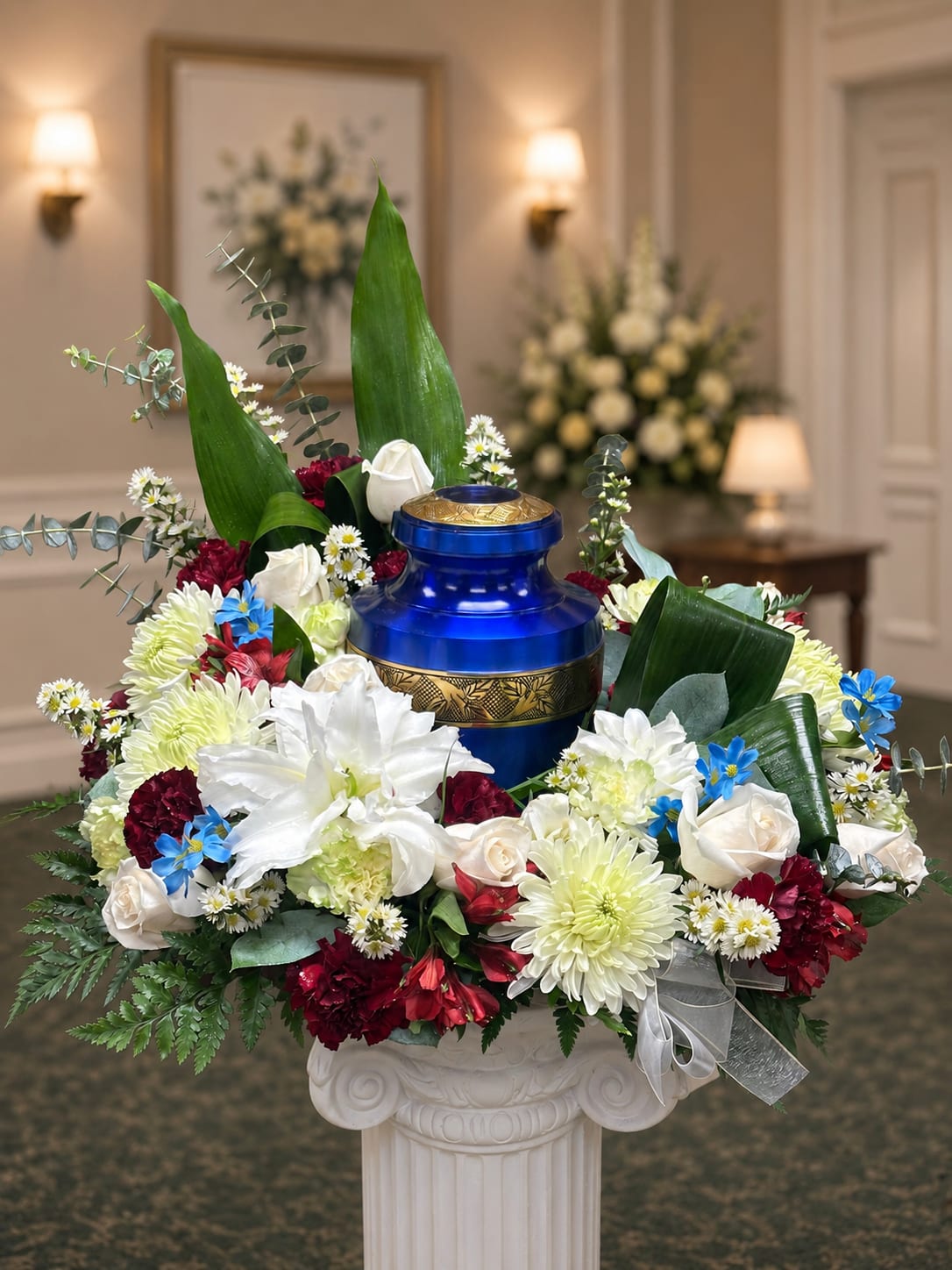 White, Burgundy and Blue Urn Wreath - A mix of white, burgundy and blue flowers surrounding the urn.