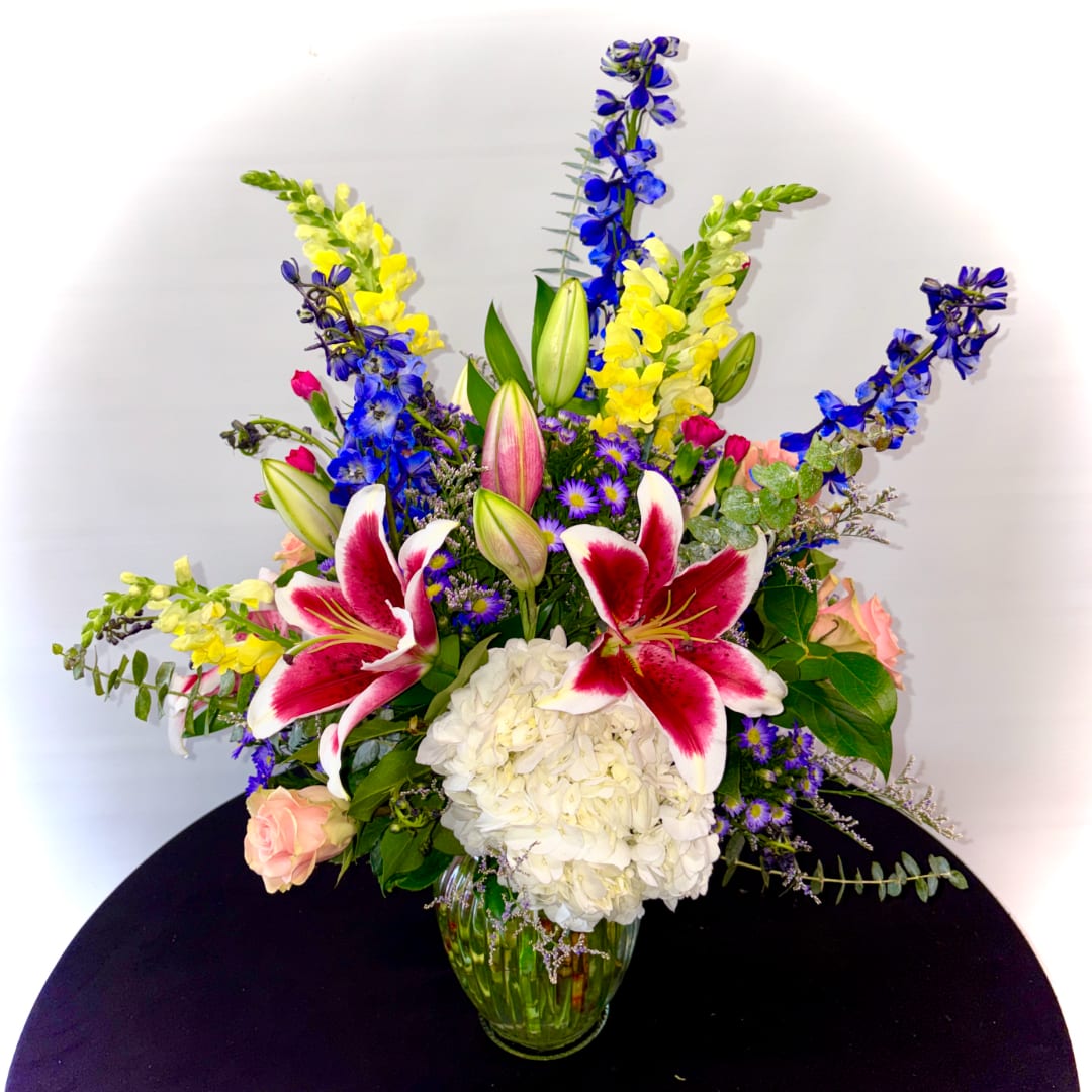 Colorful bouquet with lilies, hydrangea, and snapdragons in a glass vase