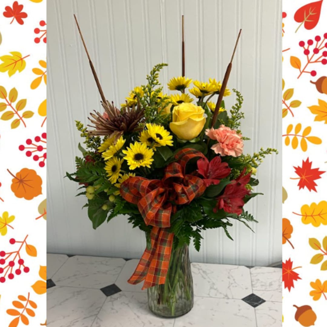 Fall bouquet with yellow roses and daisies in a glass vase