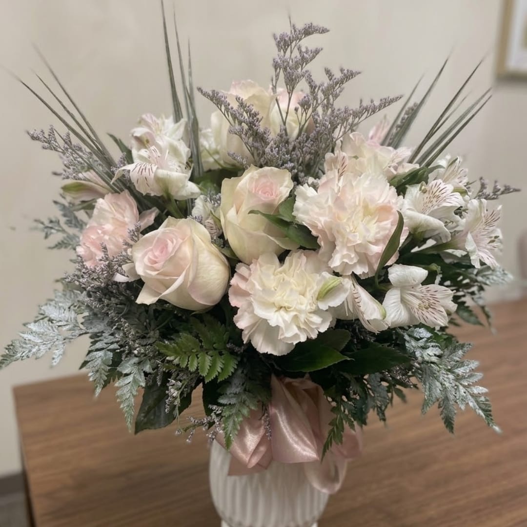 Bouquet of pale pink and white flowers in a ribbed vase